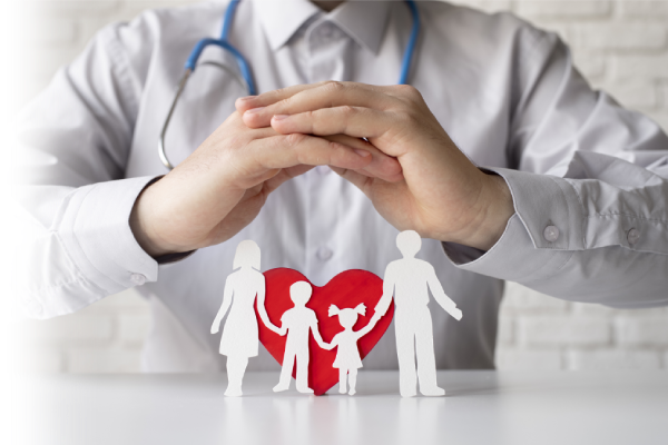Doctor’s hands protecting a cut-out family figure with a heart, representing holistic healthcare and family-oriented services at TrustScape Medical Services